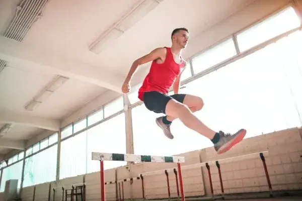 rummer jumping over a hurdle