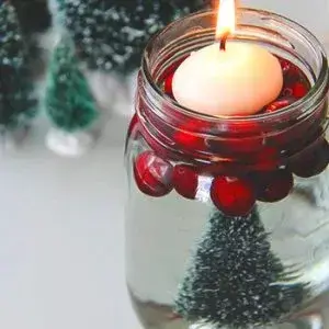 candle floating on cranberries in a jar